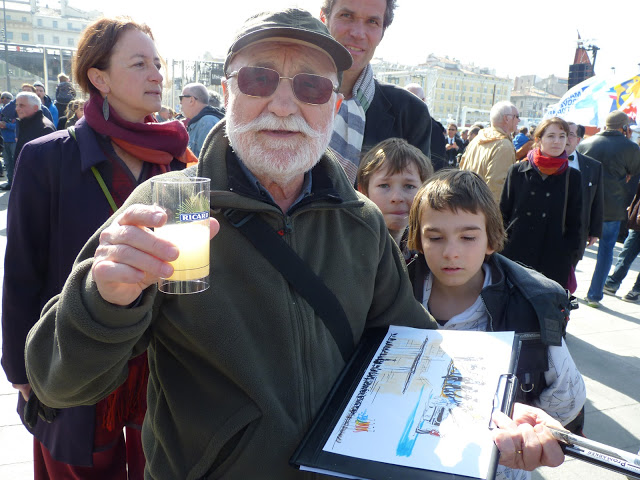 Pierre Croux, architecte, globe croqueur de Lourmarin, n'a pas raté l'occasion de croquer tout en sirotant (attention l'abus d'alcool est dangereux) les artistes qui se produisent sur le quai de la fraternité. (PHOTO P.M.-C.)