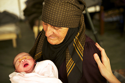 Cette grand mère tient dans ses bras le fils, celui de son fils qui vient d'être tué