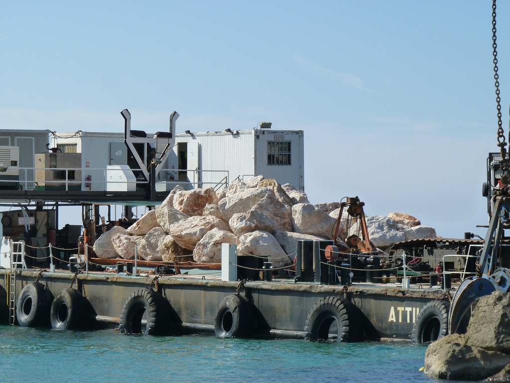Des blocs lavés sur la barge vont colmater des brèches (Photo P.M.-C.)