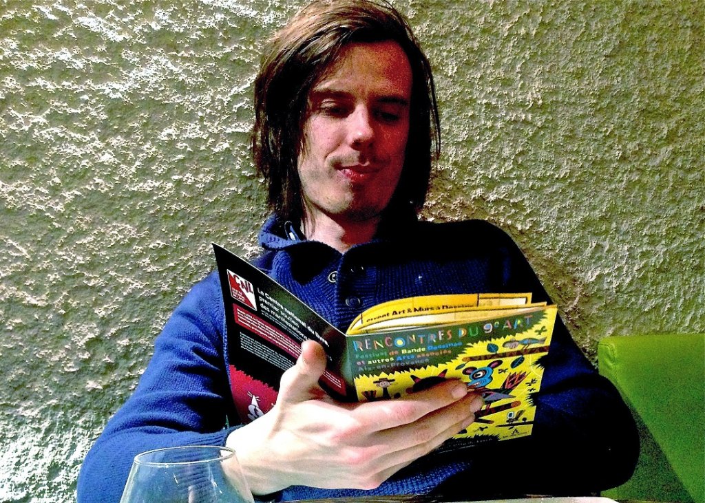 Brecht Evens lecteur attentif du programme des rencontres du 9ème art qui débutent dans quelques heures à Aix (Photo Serge Darpeix)