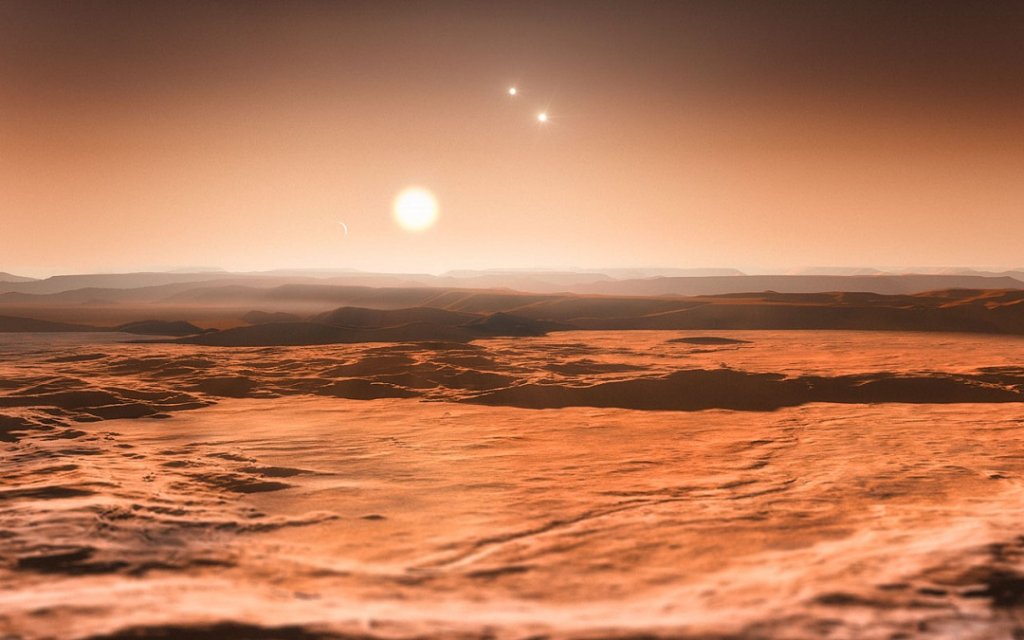 Voici une exoplanète en orbite autour d'un système stellaire triple, elle s'appelle Gliese 667 Cd. Au premier plan : son étoile hôte, celle qui lui apporte la chaleur, autrement dit 