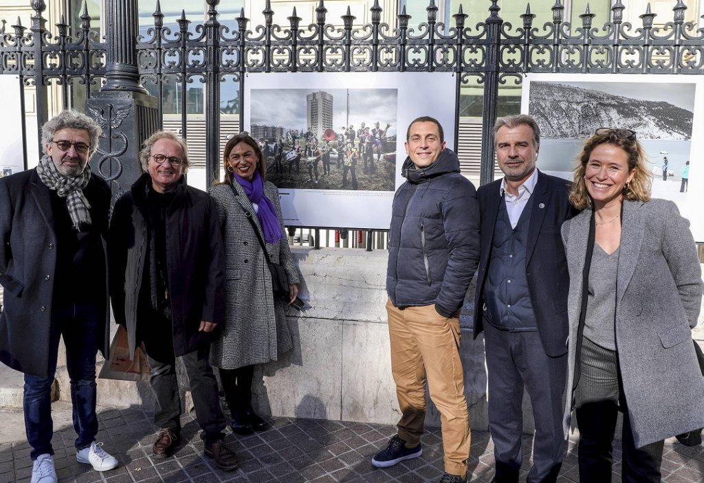 Anthony Micallef prix du photojournalisme devant sa photo accrochée aux grilles du palais de la Bourse © Nicolas VALLAURI