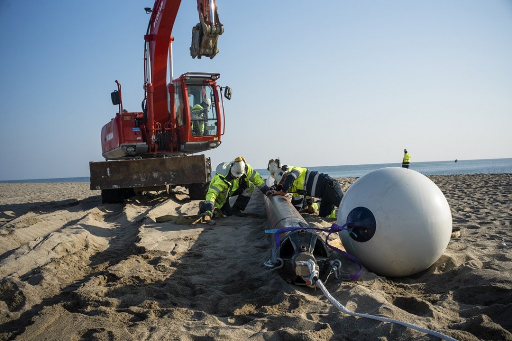L'opération consite à glisser le fourreau sous l'eau dans le forage dirigé (Photo Sébastien Xaxa)